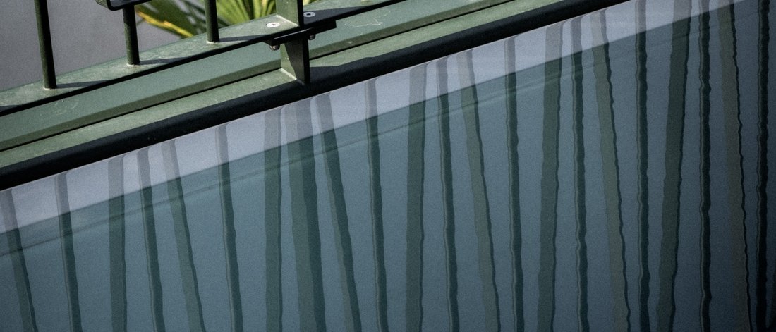 Riflessione di una ringhiera in metallo sulla superficie dell'acqua di una vasca