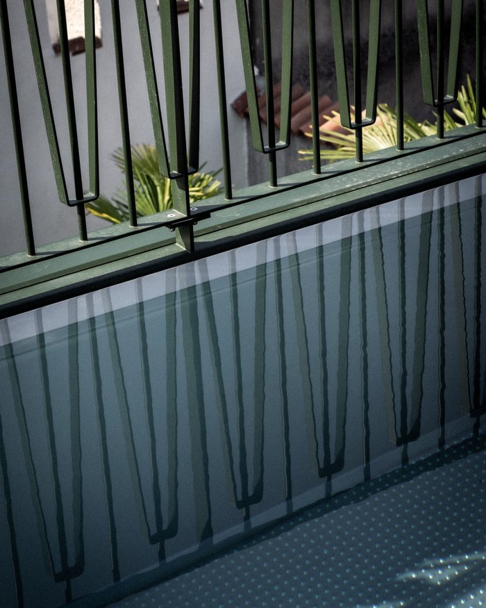 Riflessione di una ringhiera in metallo sulla superficie dell'acqua di una vasca