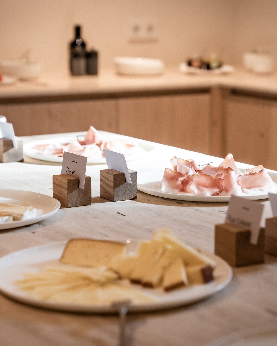 Varie tipologie di formaggi e affettati su piatti su un tavolo