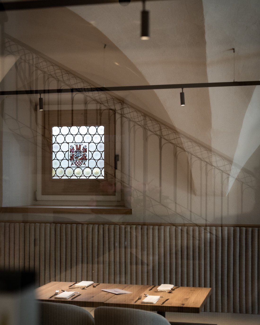 Ristorante accogliente con tavolo in legno e finestra decorata con stemma