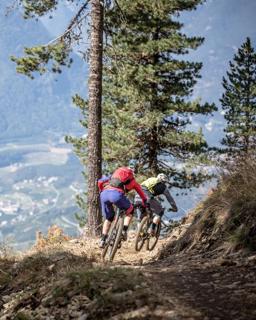 Due mountain biker su un sentiero in montagna con vista sulla valle