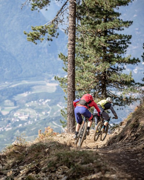 Due mountain biker su un sentiero in montagna con vista sulla valle