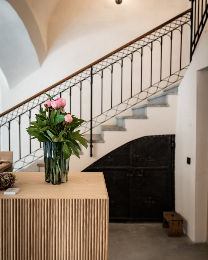 Fiori in vaso su tavolo di legno davanti a scala e porta interna