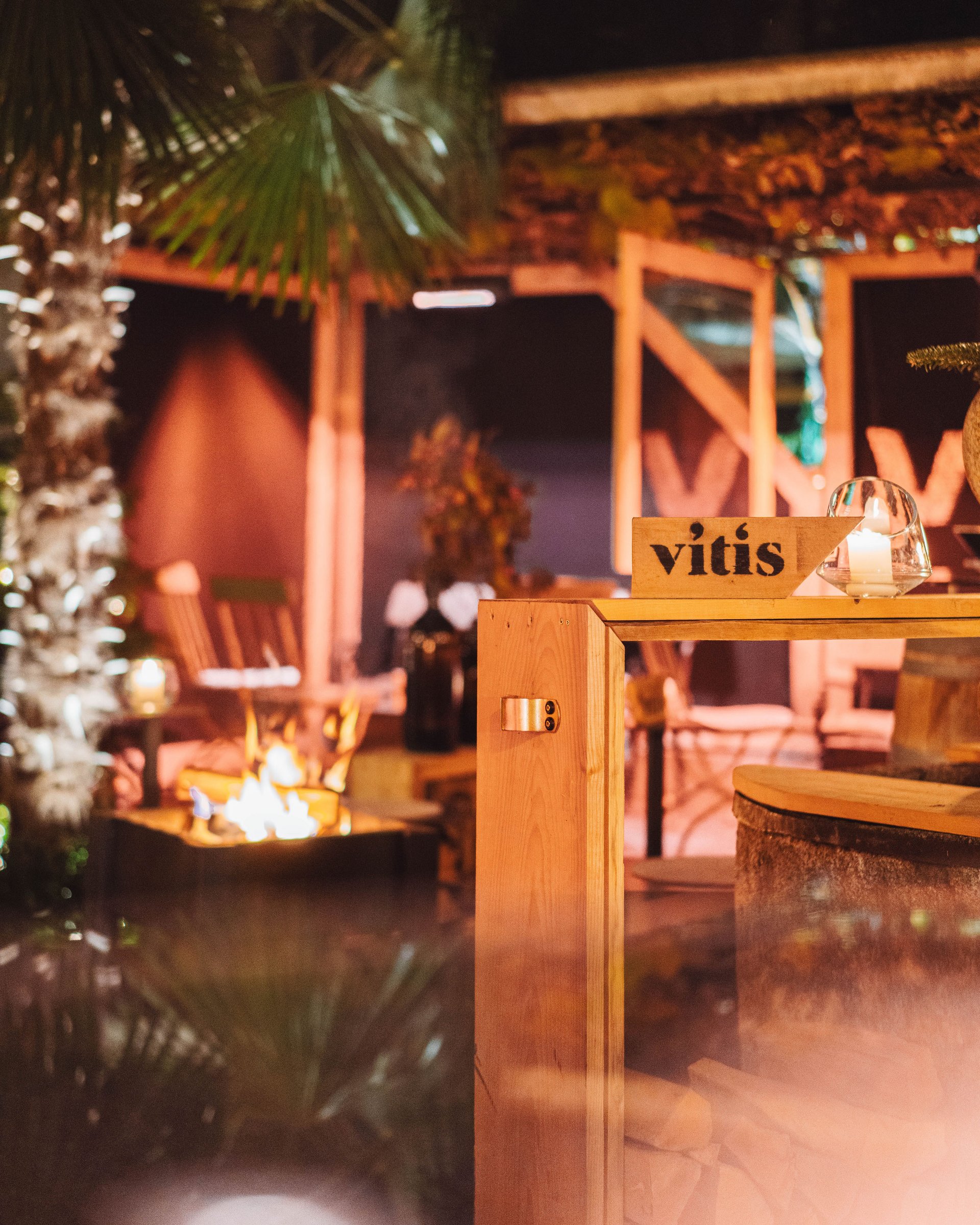 Terrazza accogliente con camino, mobili in legno e illuminazione a candele