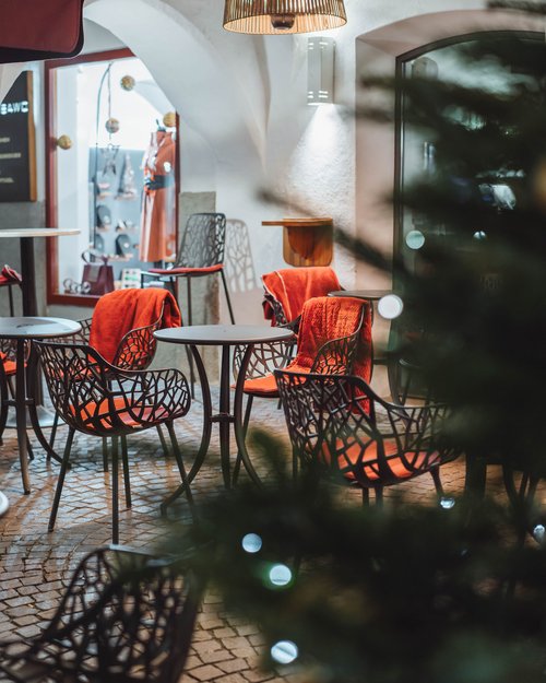 Terrazza esterna vuota con mobili e coperte rosse sotto luci soffuse