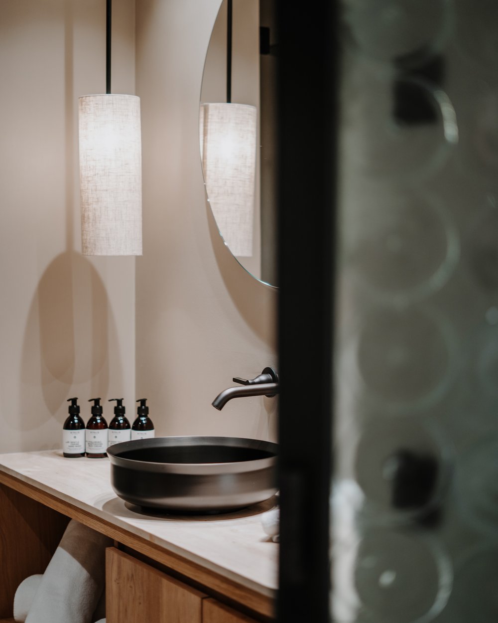 Bagno moderno con lavabo rotondo e lampada sospesa