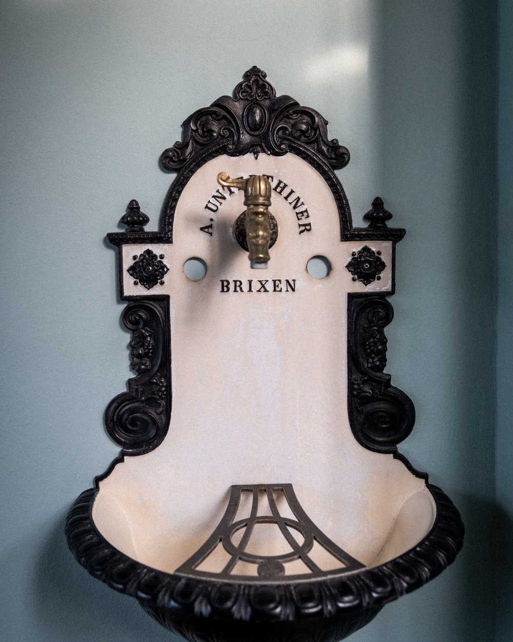 Antico lavandino da parete decorato con rubinetto dorato