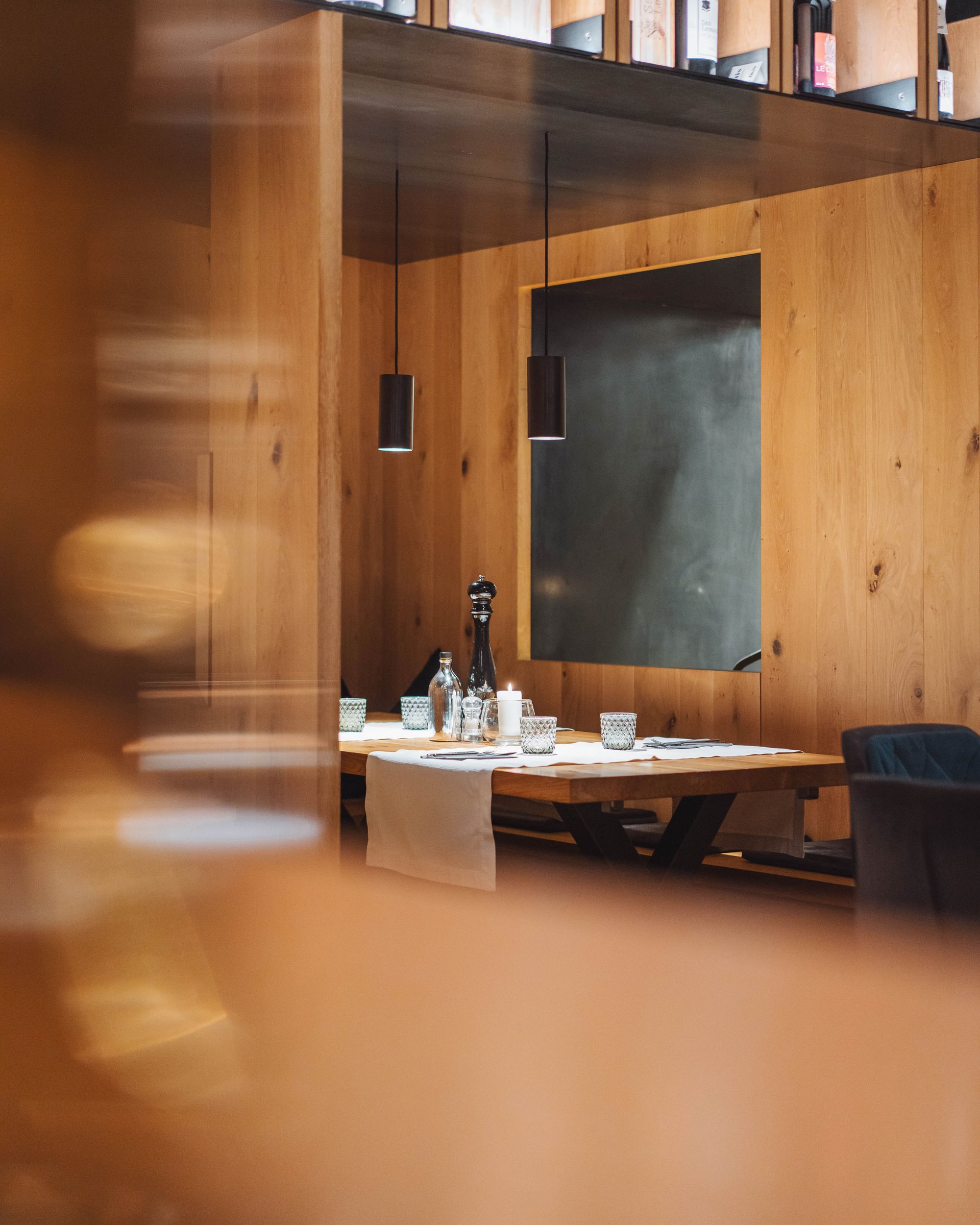 Tavolo in legno accogliente in ristorante moderno con scaffale per vini