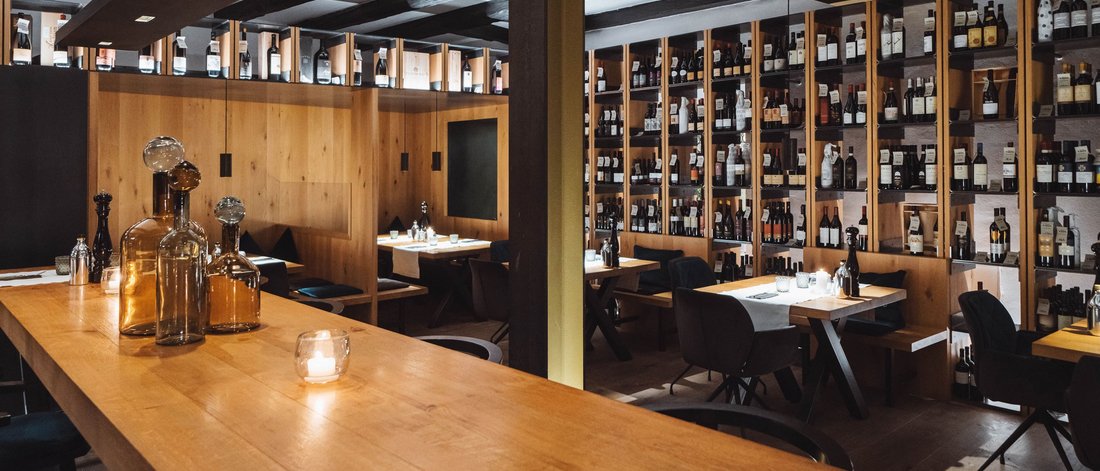 Accogliente area vino di un ristorante con scaffali in legno e tavoli