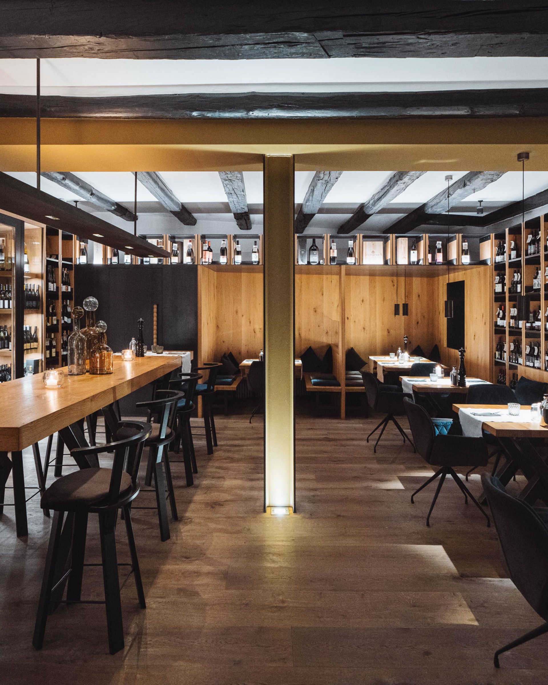 Ristorante accogliente con tavoli in legno e scaffali di vini alle pareti