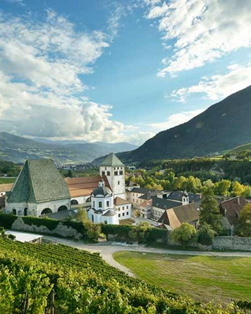 Monastero in paesaggio verde con montagne sotto un cielo nuvoloso