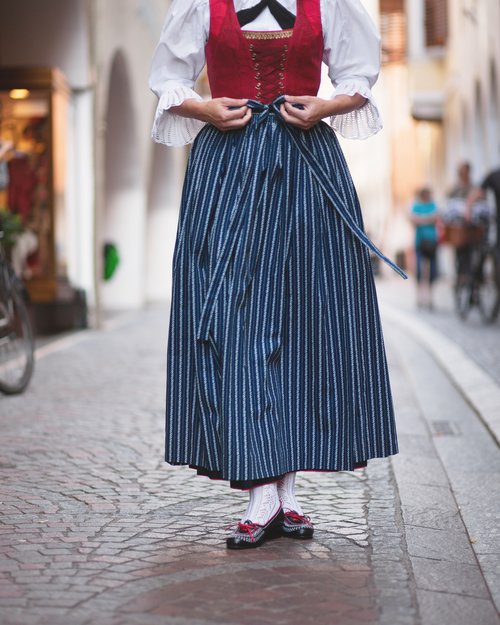 Donna in abito tradizionale con corpetto rosso e gonna blu a righe
