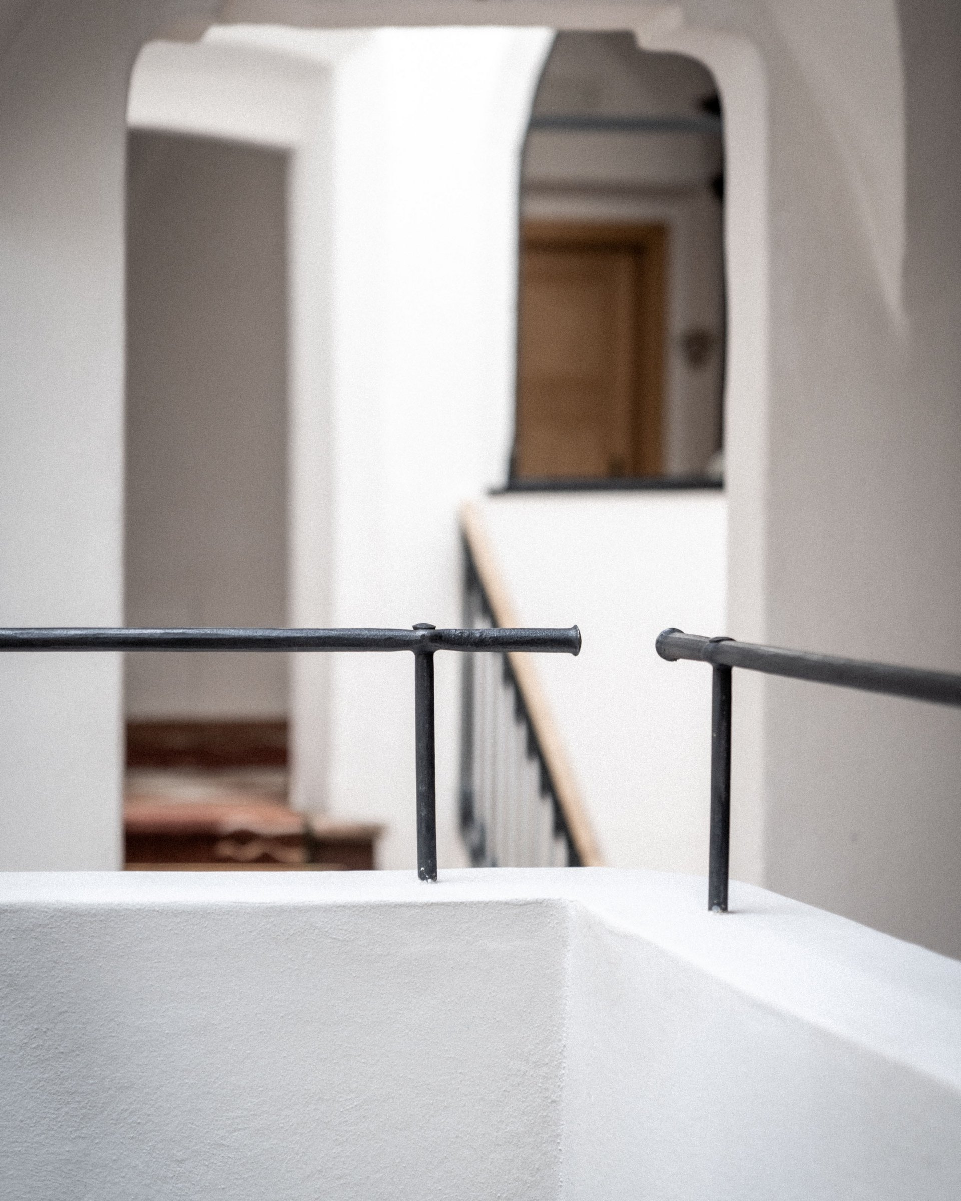 Cortile interno moderno con pareti bianche e ringhiera nera