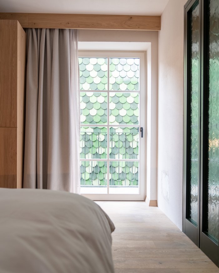 Camera da letto con finestra e parete esterna di scaglie verdi