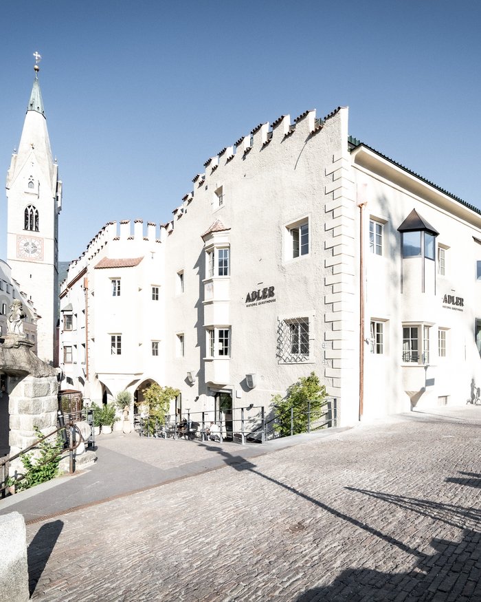 Edificio storico Adler con torre e ponte in pietra sotto il sole