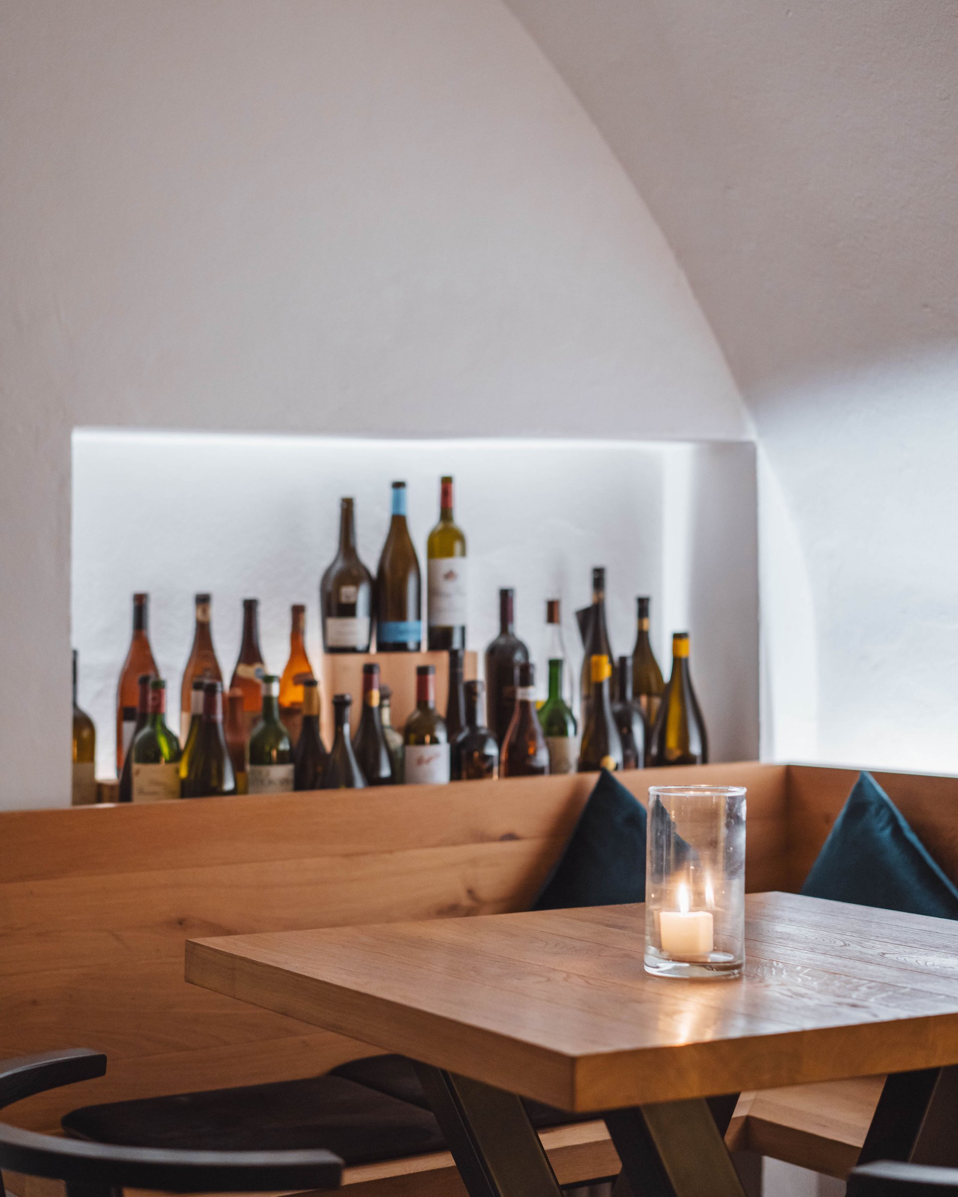 Angolo accogliente con candela e bottiglie di vino sullo sfondo