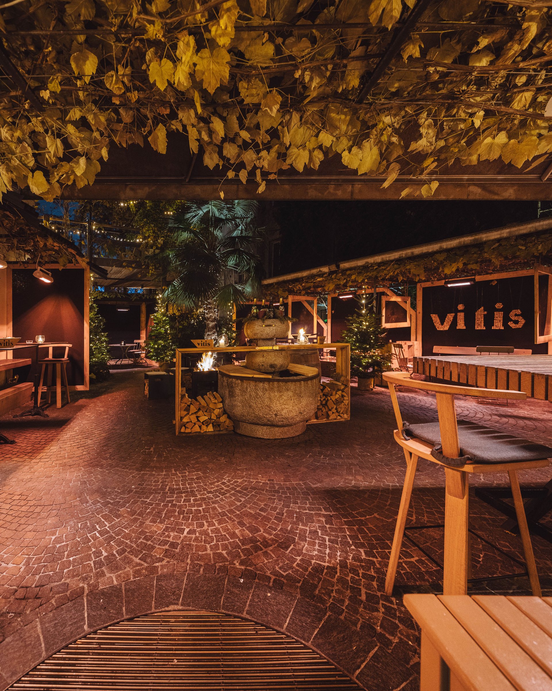 Bar all'aperto accogliente con soffitto in legno e fuoco acceso di notte