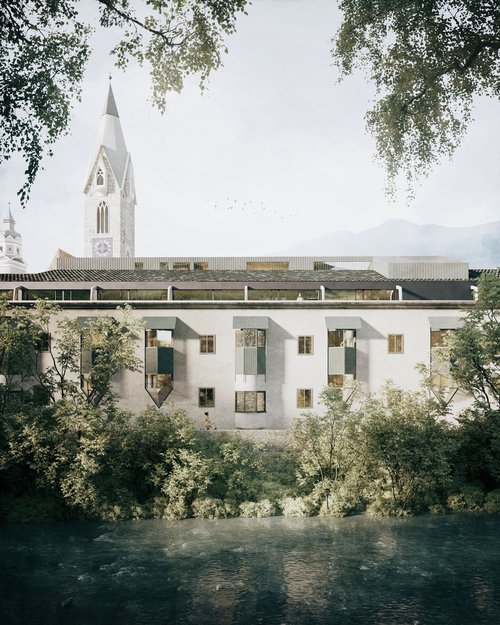 Edificio antico con campanile a punta e fiume in primo piano