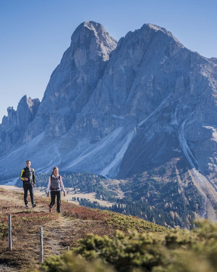 Escursionisti davanti a una grande montagna con cielo blu limpido