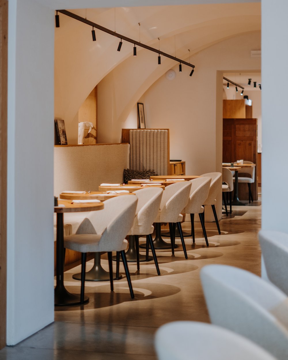 Area ristorante moderna vuota con sedie beige e tavoli in legno